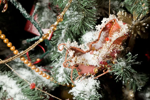 Christmas ornaments in form of sledge on artificial fur-tree, br — Stock Photo, Image