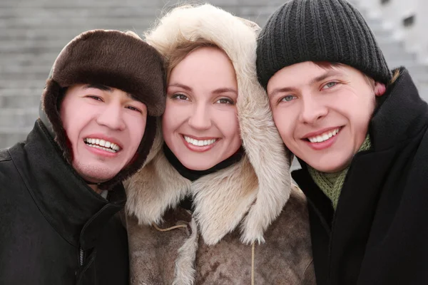 Three friends smiling and looking at camera, half body, winter d — Stock Photo, Image