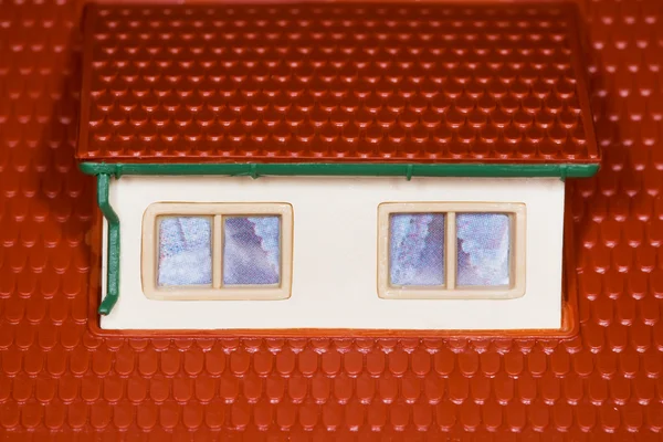 Poddasze na dachu domu plastikowe zabawki, dwa okna — Zdjęcie stockowe