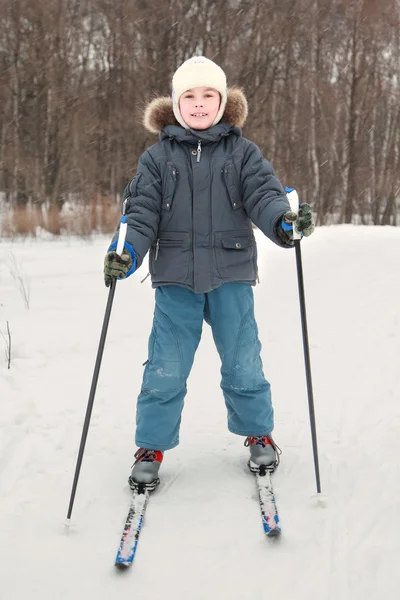 Niño en vestido deportivo cálido esquiando en el bosque, cuerpo entero, mira — Foto de Stock