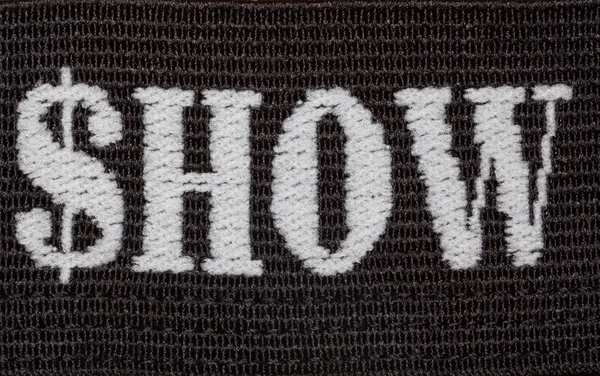 Palavra "show" bordado em fio branco em tecido preto — Fotografia de Stock
