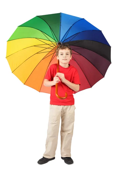 Маленький мальчик в красной рубашке с большим разноцветным зонтиком стоя — стоковое фото