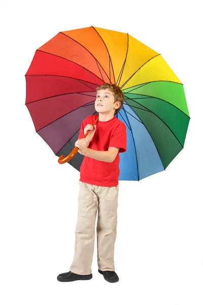 Jongen in het rode shirt met grote veelkleurige paraplu staande op whit — Stockfoto