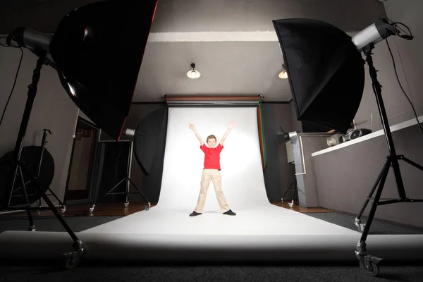Interior of professional photo studio boy in red shirt standing — Stock Photo, Image