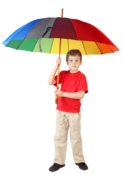 Malý chlapec v červené košili s velkým vícebarevné deštník stojící — Stock fotografie