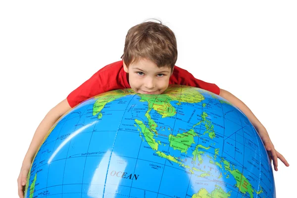 Boy in red shirt lies on inflatable globe isolated on white back — Stock Photo, Image