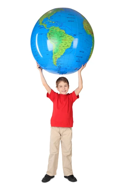 Niño en camisa roja sonriendo y sosteniendo globo inflable grande sobre h —  Fotos de Stock