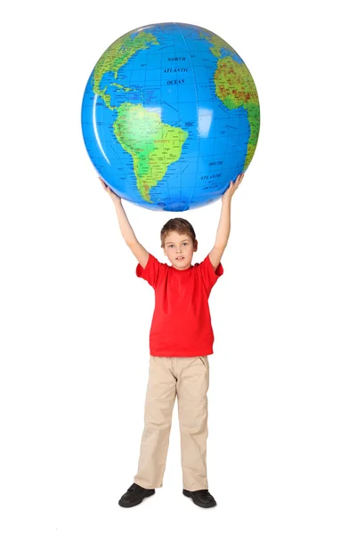 Boy v červené košili drží velký nafukovací koule nad jeho hlavou plnou — Stock fotografie