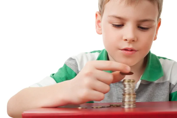 Boy in striped T-shirt stacking up coins isolated on white bac — Stock Photo, Image