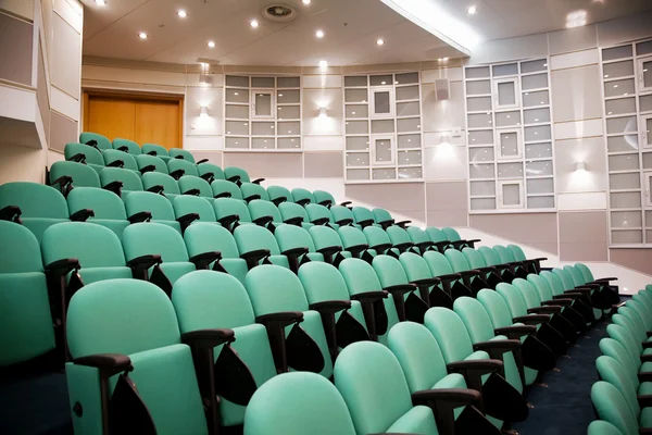 Salle de conférence vide, rangées de chaises, huit numéros en plan — Photo