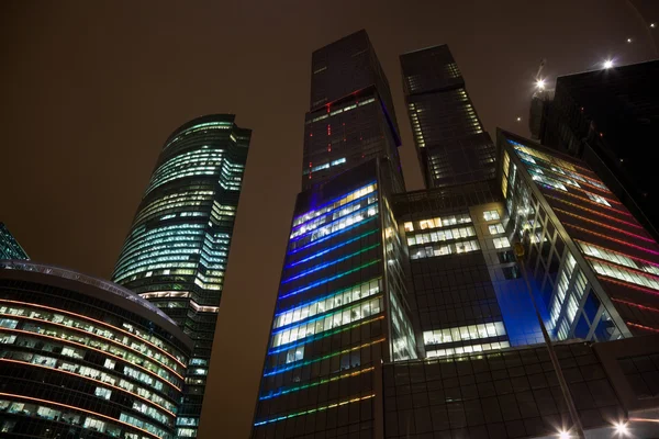 Modernin toimistorakennuksen ylimmät kerrokset yöllä, pilvenpiirtäjä mos — kuvapankkivalokuva