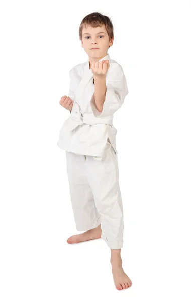 Karateka chico en kimono blanco de pie aislado sobre fondo blanco — Foto de Stock