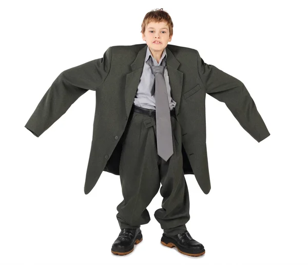 Little boy in big grey man's suit and boots nads at sides isolat — Stock Photo, Image