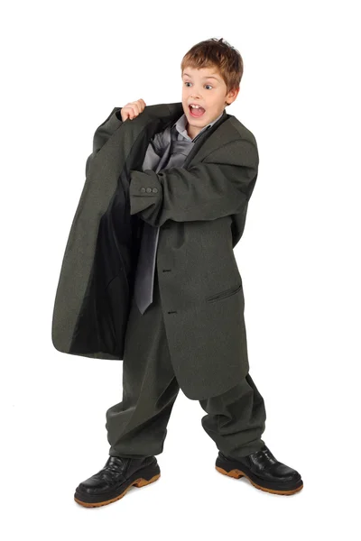 Little boy in big grey man's suit and boots hand in pocket isola — Stock Photo, Image