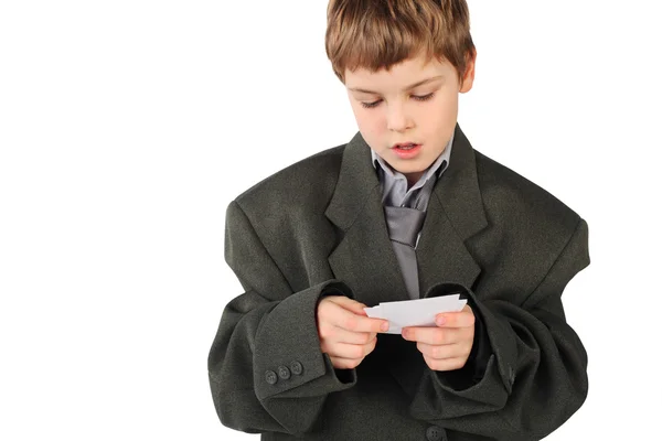 Little boy in big grey man's suit looking at business card isol — Stock Photo, Image