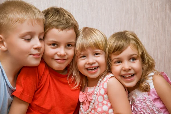 Rindo crianças quatro juntos em quarto acolhedor, duas meninas bonitas um — Fotografia de Stock