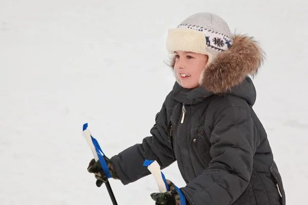 Kleiner Junge in warmem Sportkleid beim Skifahren im Wald, Halbkörper, Blick lizenzfreie Stockfotos