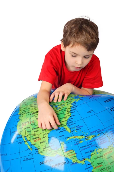 Boy in red shirt leans on inflatable globe isolated on white bac — Stock Photo, Image