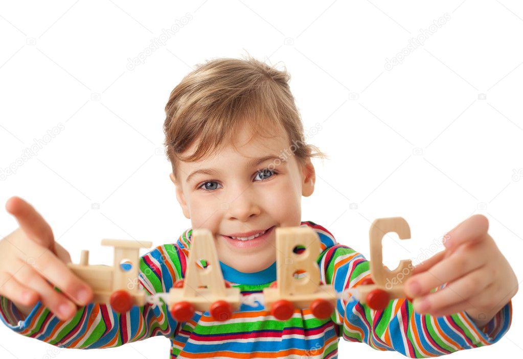 Pretty little girl keeps in hands toy wooden steam locomotive wi