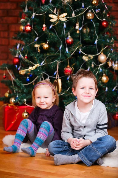 Δύο παιδιά κοντά χριστουγεννιάτικο δέντρο — Φωτογραφία Αρχείου