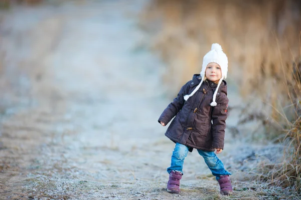Klein meisje buitenshuis op winterdag — Stockfoto