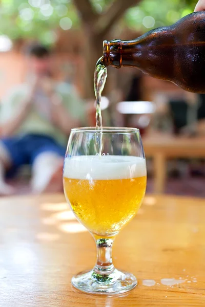 Бутылка пива, вливающаяся в стакан — стоковое фото