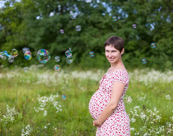 Pregnant woman with soap bubbles — Stock Photo, Image