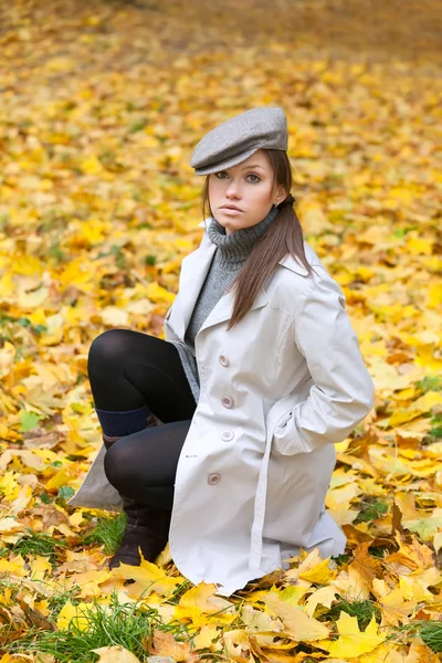Krásná žena v čepici a bílém kabátě — Stock fotografie