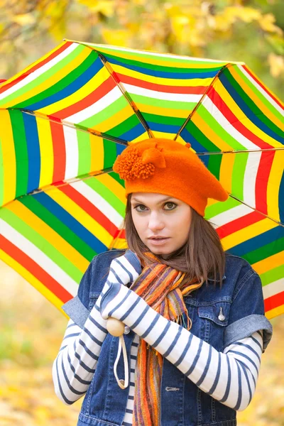 Joven chica bonita con paraguas rayado — Foto de Stock