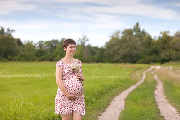 Femme enceinte avec bouquet de camomille — Photo