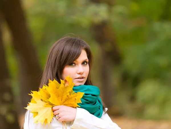 Vacker kvinna stående med gula blad — Stockfoto