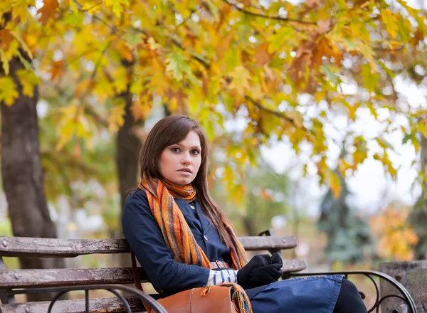 Young woman sitting on the bench — Stock Photo, Image