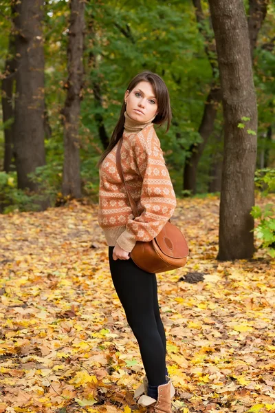 Девушка с сумочкой стоит в лесу — стоковое фото