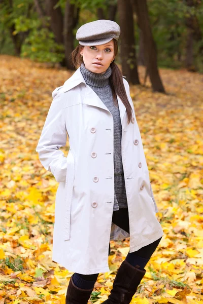 Hermosa mujer con gorra y abrigo blanco — Foto de Stock