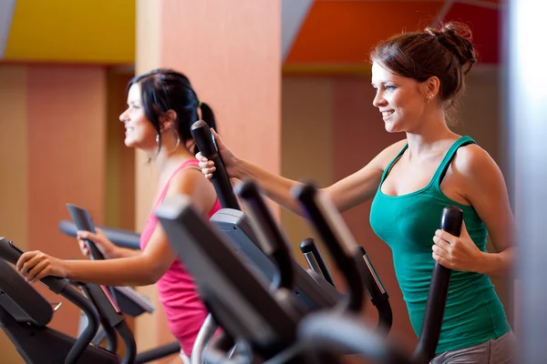 Young women in gym on stepper machine — Stock Photo, Image
