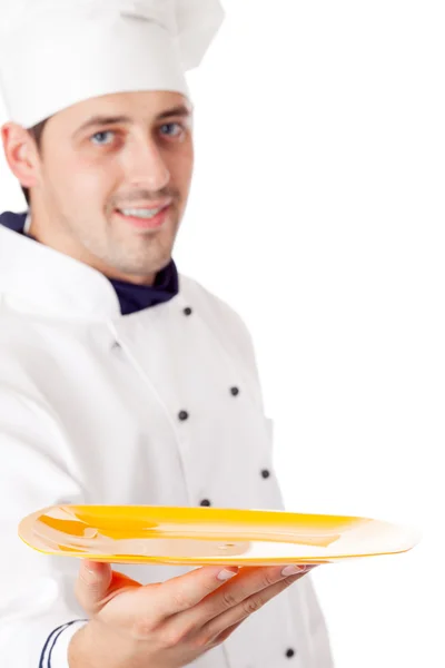 Koch hält Teller mit etwas — Stockfoto