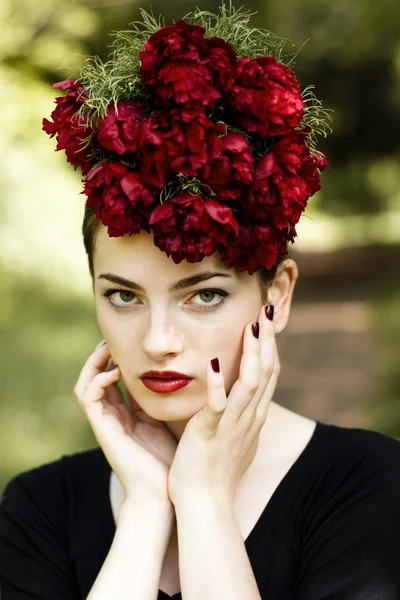 Vrouw met rode lippenstift en bloemen op het hoofd — Stockfoto