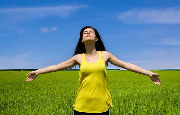 Gelukkige vrouw genieten van zon in het veld — Stockfoto