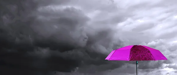 Regenschirm unter bewölktem Himmel — Stockfoto