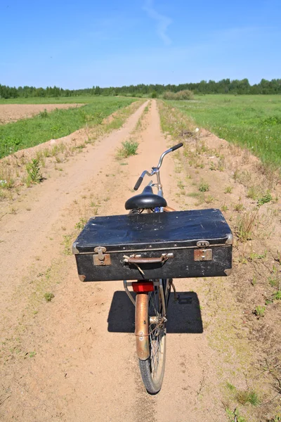 Старый велосипед на сельской дороге — стоковое фото