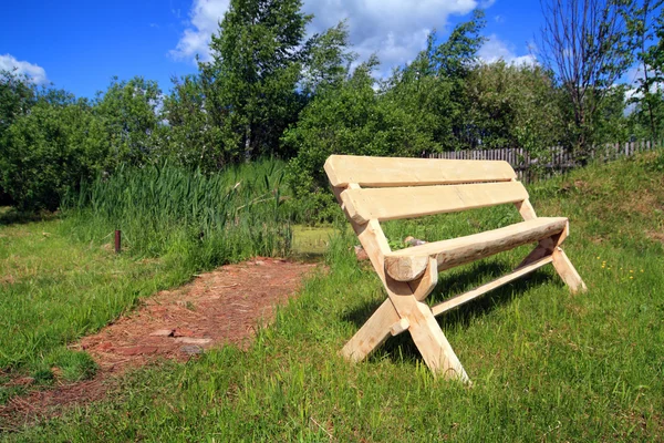 Dřevěná lavička v letním parku — Stock fotografie