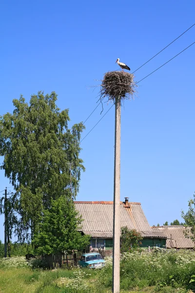 Crane on pole amongst villages — Stock Photo, Image