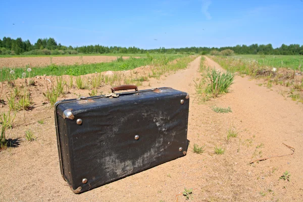 Old valise on rural road — Stock Photo, Image
