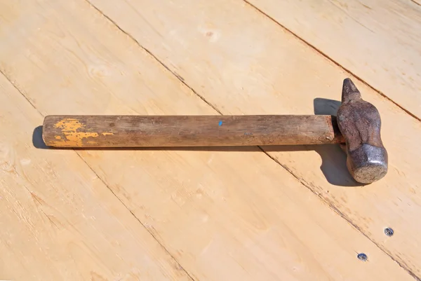 Vieux marteau sur planche en bois — Photo