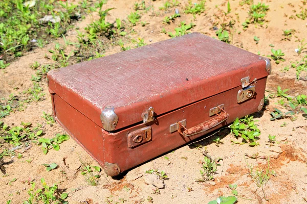 Velho valise em areia amarela — Fotografia de Stock