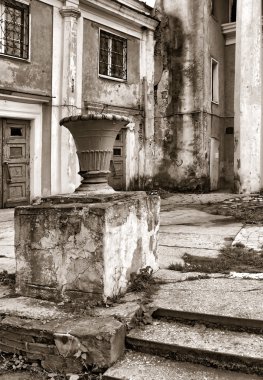 Decorative urn near old buildings clipart