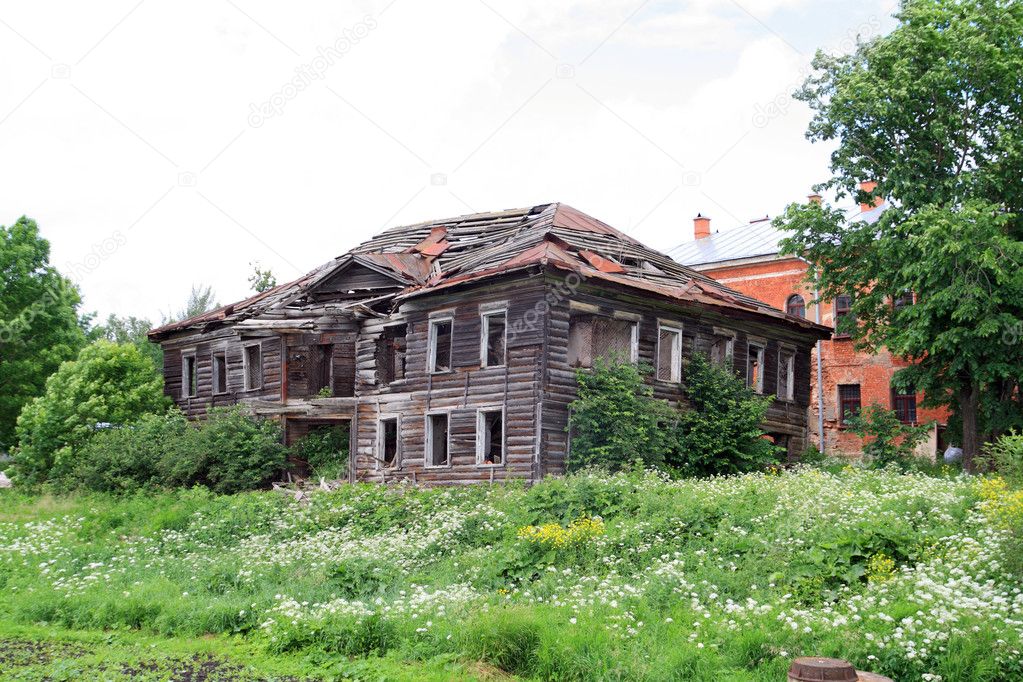 Old wooden house on green field