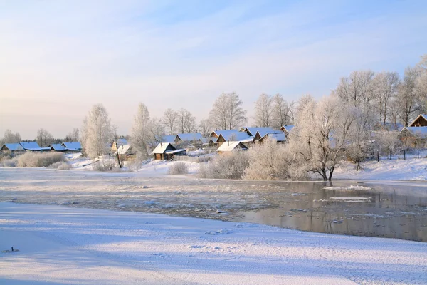 Winter dorp aan kust rivier — Stockfoto