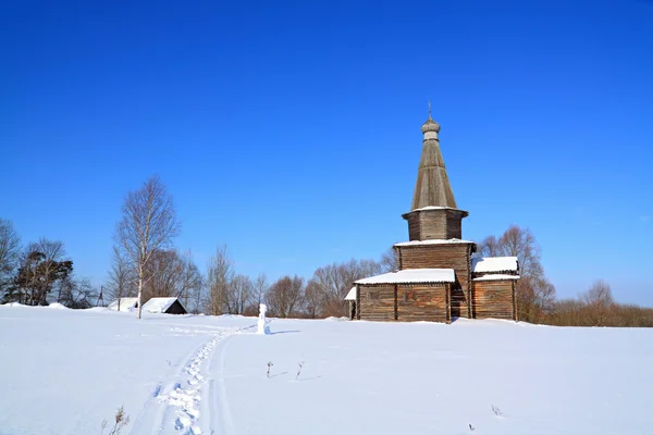 Деревянная часовня на снежном поле — стоковое фото