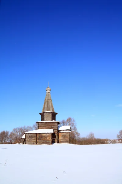 Wooden chapel on snow field — Stock Photo, Image